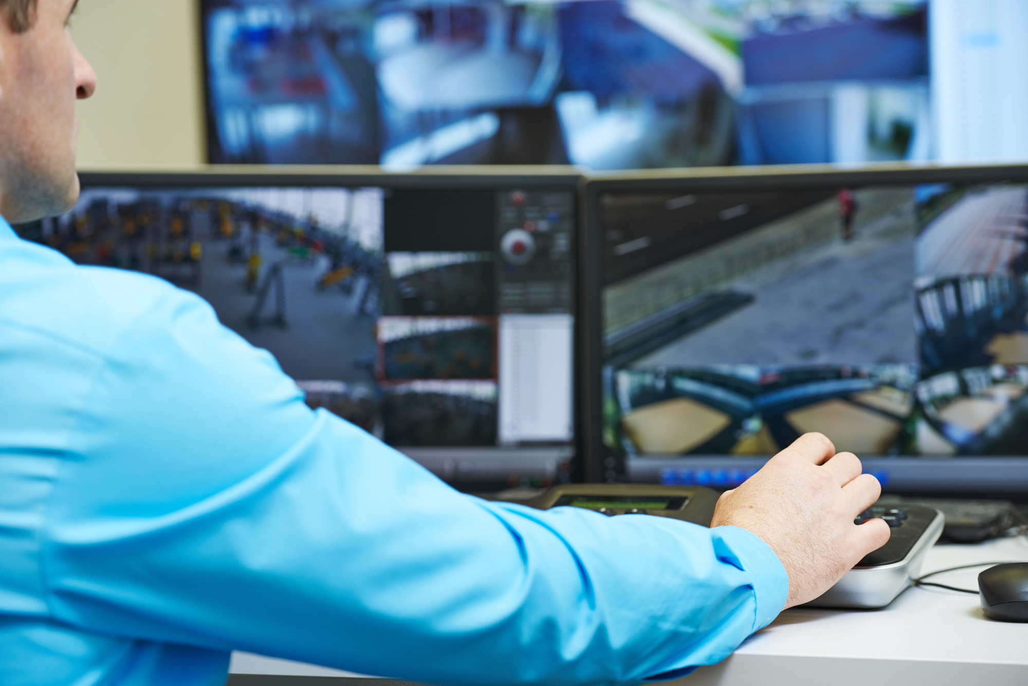 Commercial fire alarms monitoring center with security operator at workstation