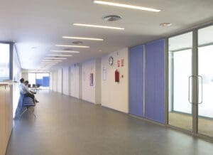 Medical office fire safety systems with extinguisher and signage in a hallway